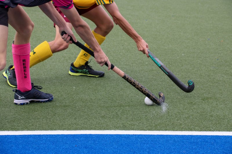 Hockeysters strijden om de bal op een kunstgrasveld